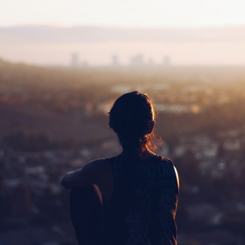 woman sitting on brown rock during daytime