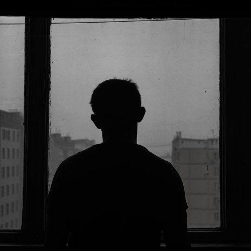silhouette of man standing near window